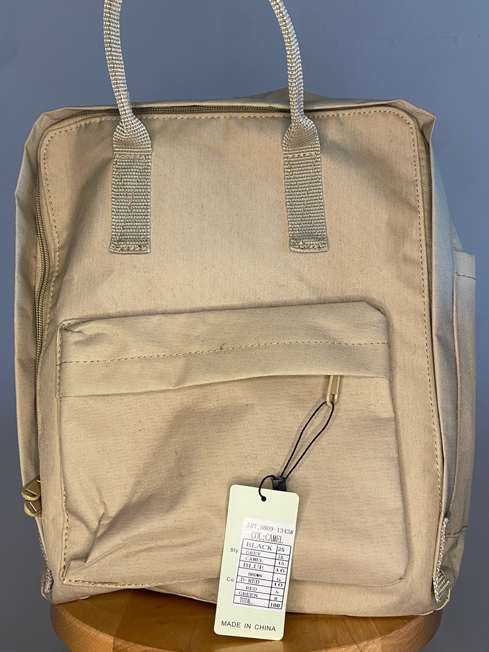 Beige backpack with laptop sleeve and zip pockets